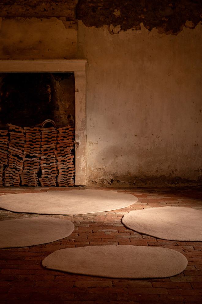 An organic felted wool rug at the foot of the bed