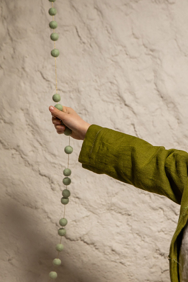 Felt pompons on a golden thread to create a playful garland