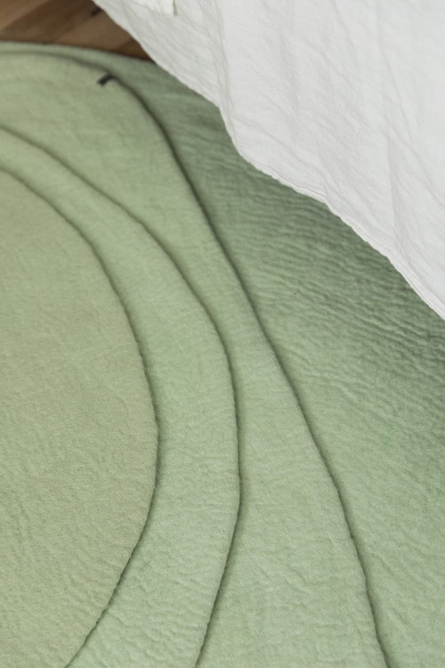 Des tapis organiques vert menthe pour habiller le sol de la chambre