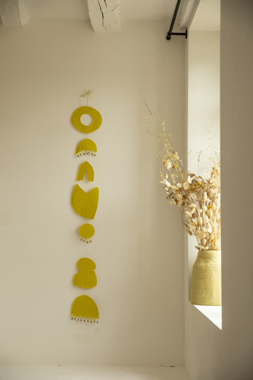 Mobile chakra artisanal jaune suspendu au mur
