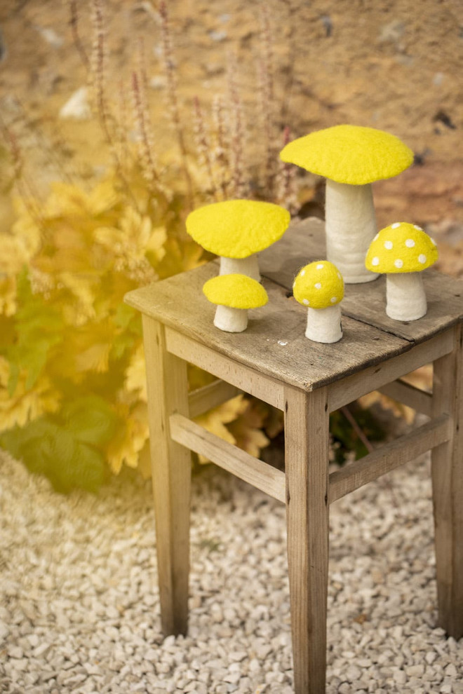 Des champignons en laine sur une table en bois en objet de décoration