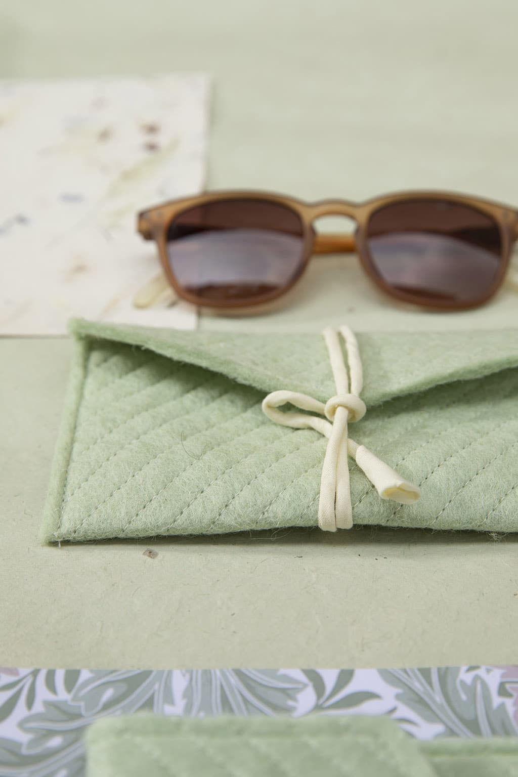 Ein elegantes Brillenetui aus mintgrünem Wollfilz mit einer kleinen Baumwollkordel