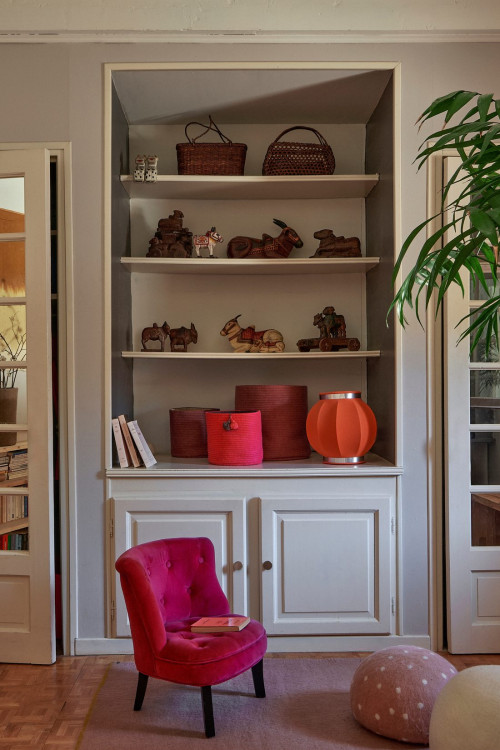 Bookcase, pink armchair and felt poufs
