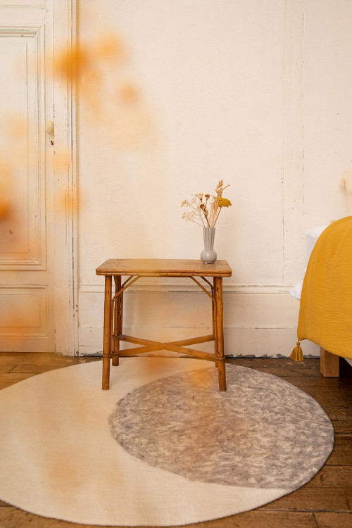 Round carpet with moon print in white wool felt for a warm decoration of the room
