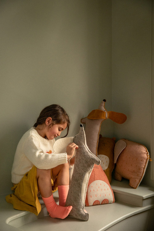 Enfant jouant avec des coussins en forme d'animaux