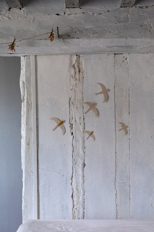 golden swallows poetically decorate a white stone wall