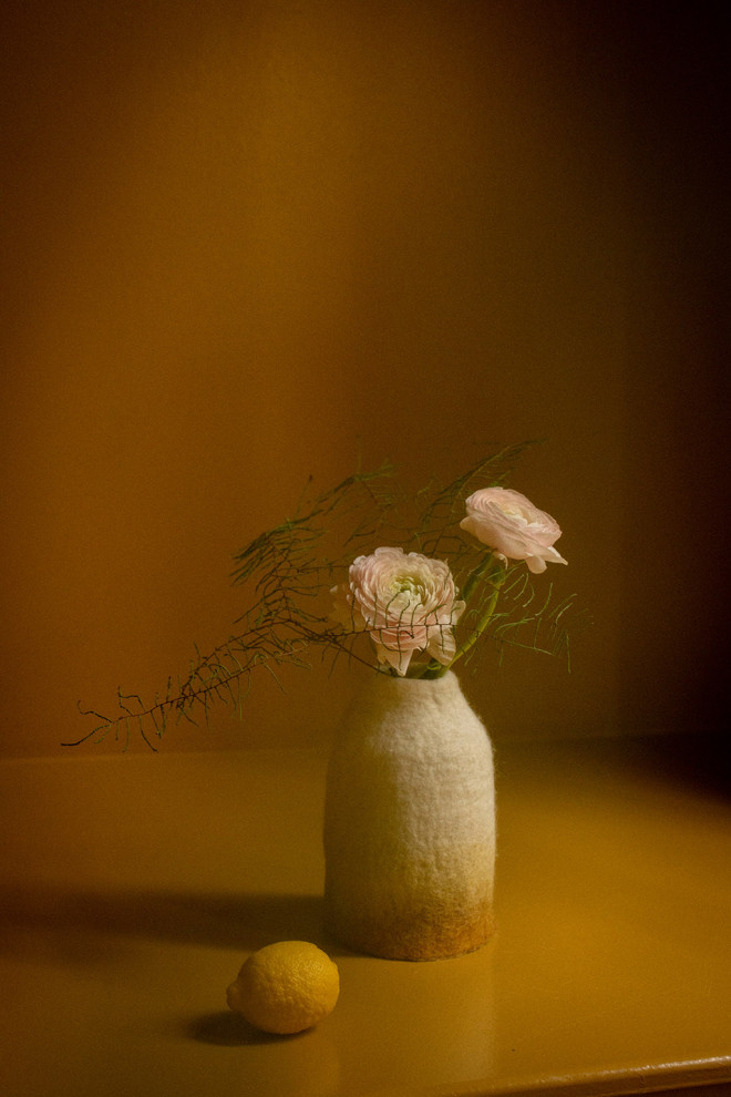 Duo of colorful boiled wool vases placed on a wooden bench