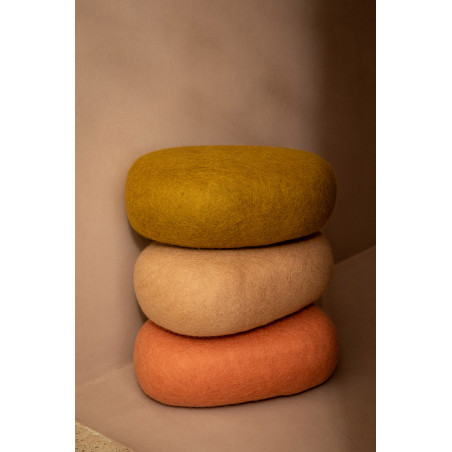 Oval felt cushions stacked along a wall