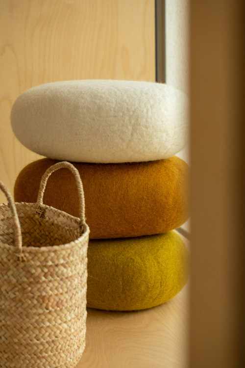 Stack of felted cushions and wicker bags for an elegant decoration