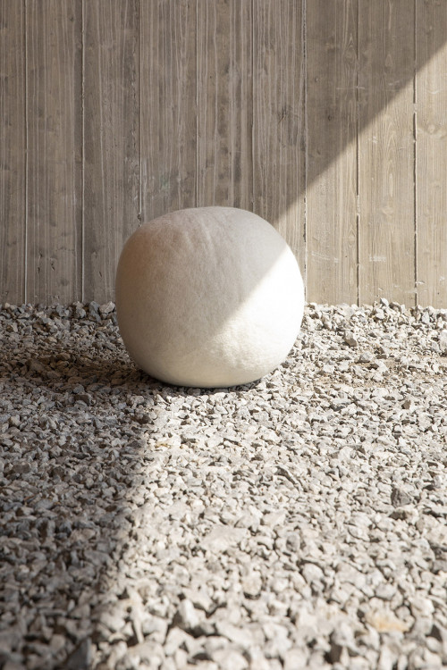 White felted wool pouf in the sun
