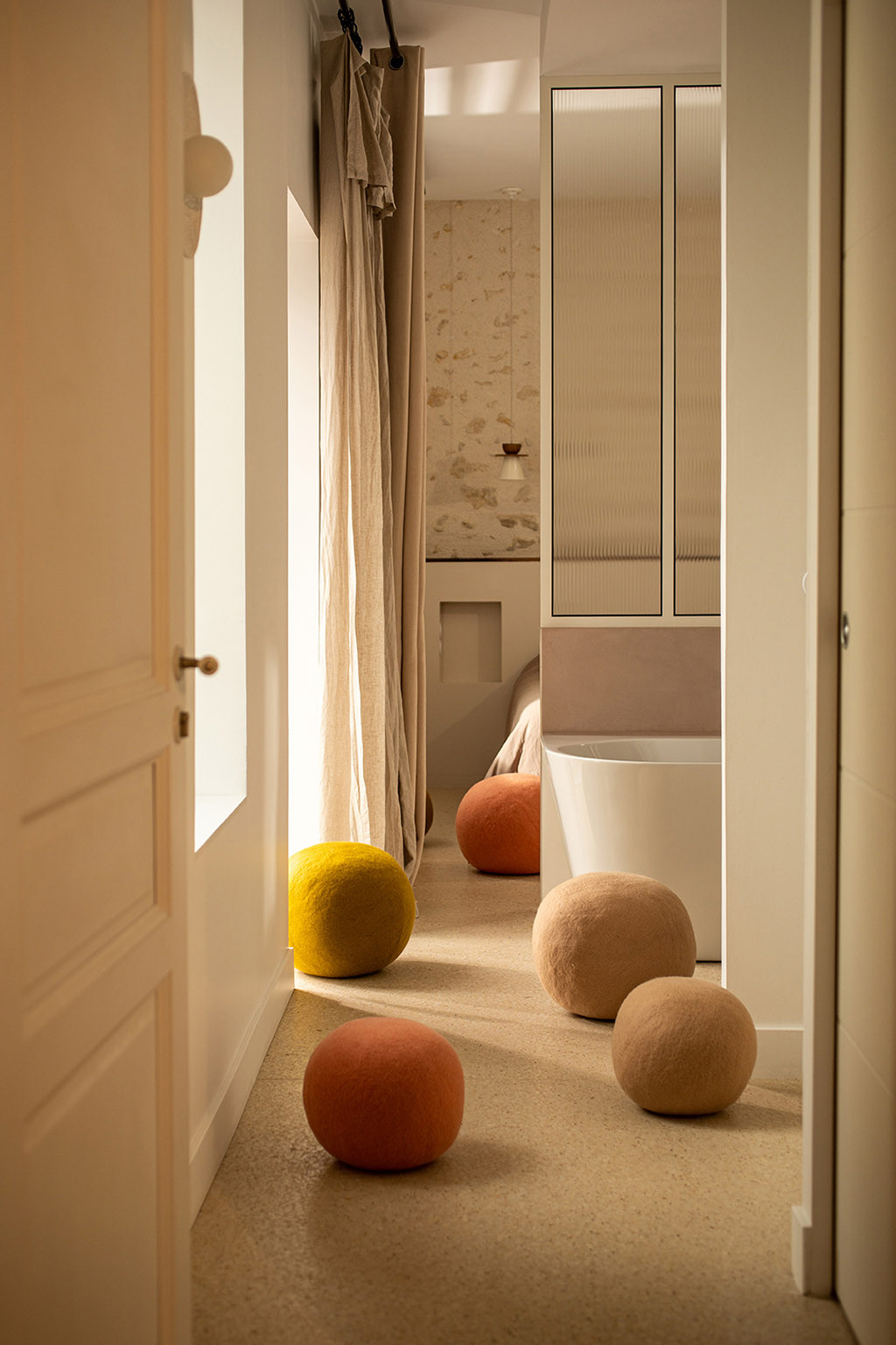 Large felt poufs decorate a room