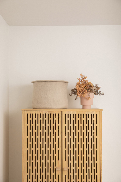 storage basket with its cover on the cupboard of a room