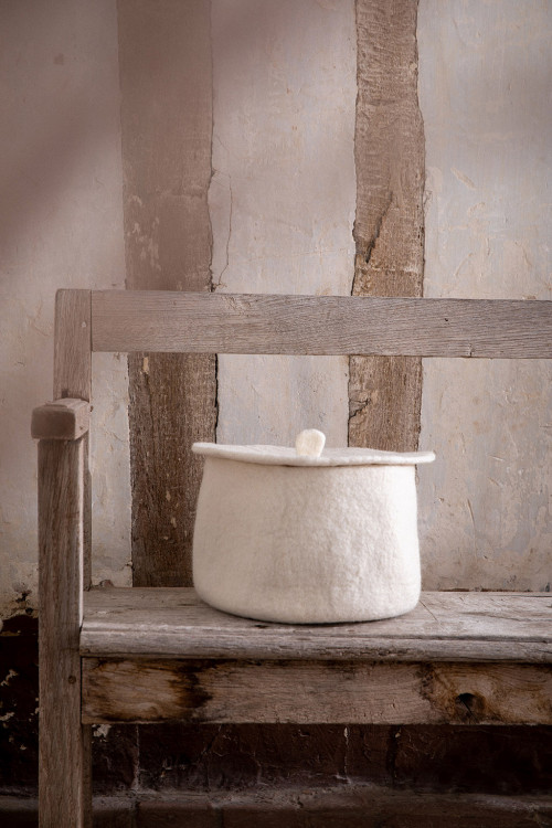 a basket placed on a bench with its cover for a felted decoration a basket placed on a bench with its cover for a felted decoration