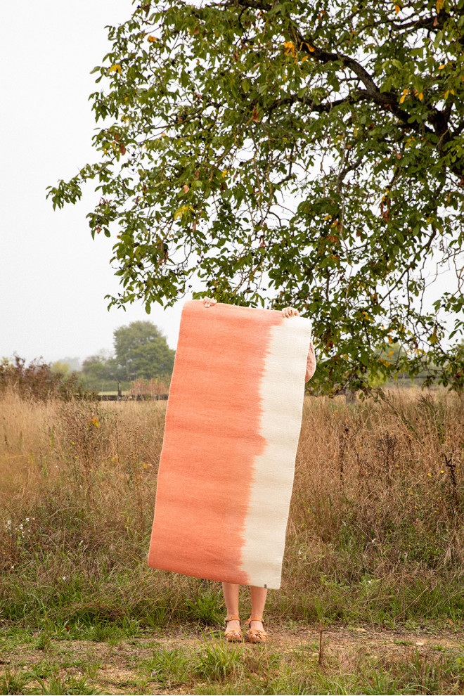 Pink and white rectangle felt carpet held by a woman