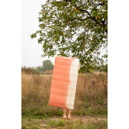 Tapis en feutre rectangle rose et blanc tenu par une femme