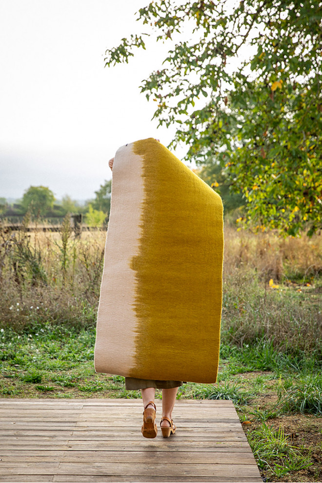 Pink and white rectangle felt carpet held by a woman