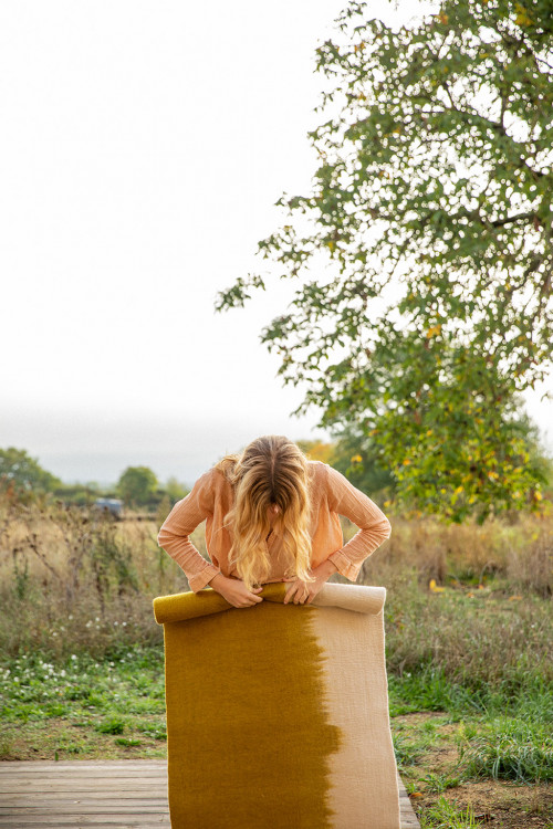 Woman rolling a grey and green felt carpet