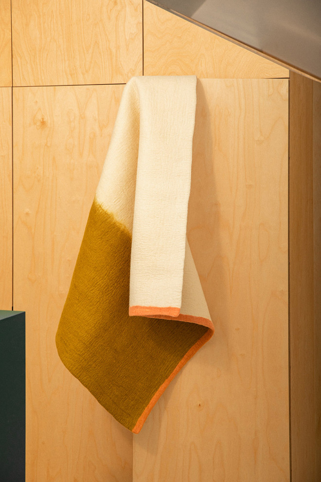 Tapis rectangulaire en feutre de laine blanc vert et rose suspendu à une porte