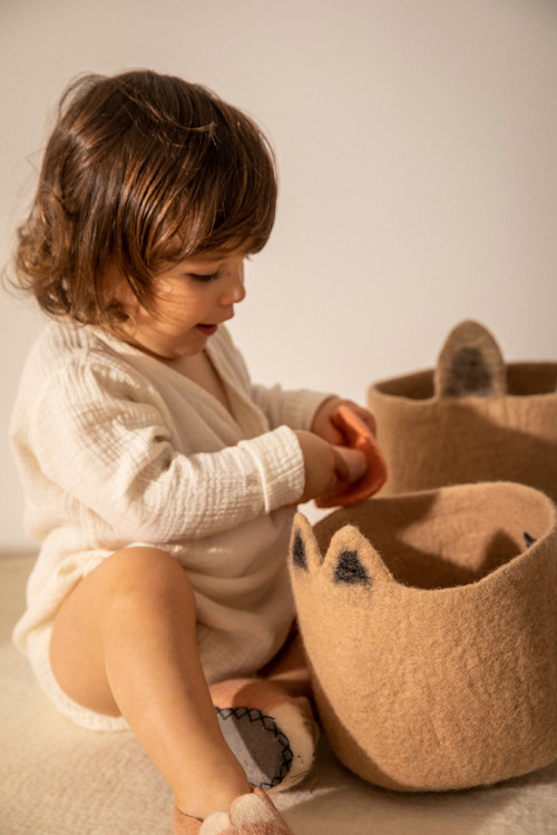 a child stores these treasures in a felt basket
