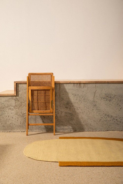 Oval felted wool carpet and folded chair