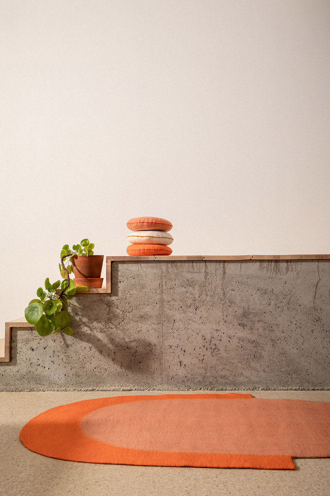Two-tone oval wool felt carpet in yellow and ochre for a modern decoration