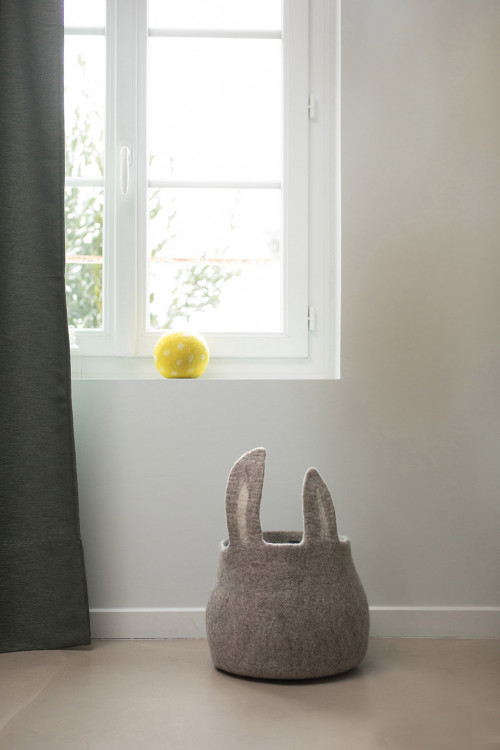 a woolen basket with rabbit ears in a child's room