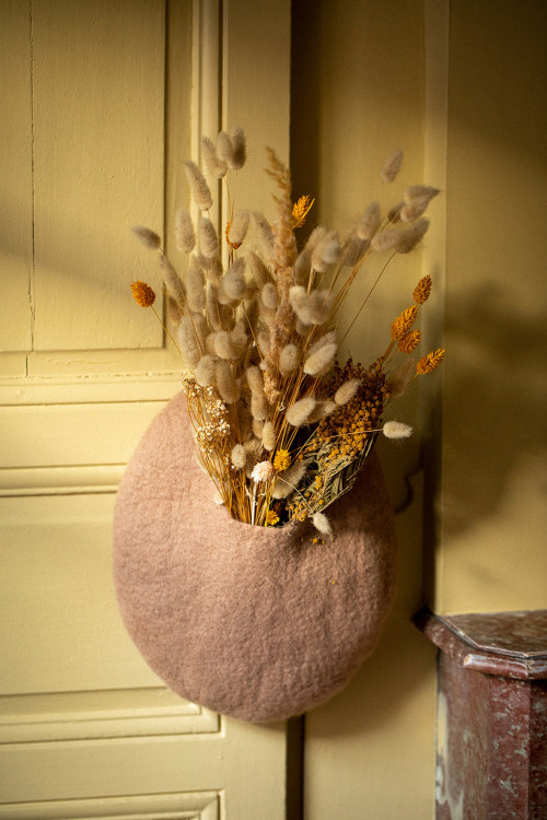 a pink boiled wool basket with dried flowers a pink boiled wool basket with dried flowers