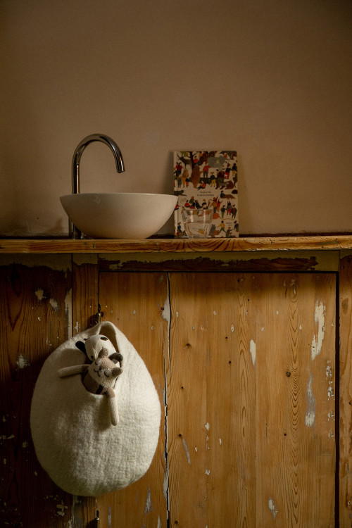 a decorative and useful basket hung on a bathroom cabinet