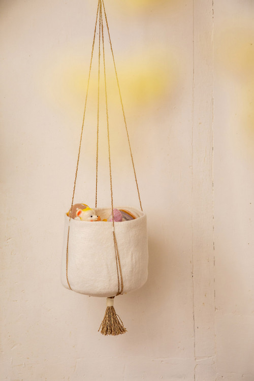 a cushion stored in a hanging felt basket for a cosy atmosphere