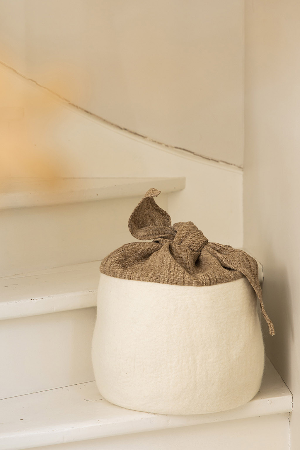 an elegant storage basket with a nettle fiber bow