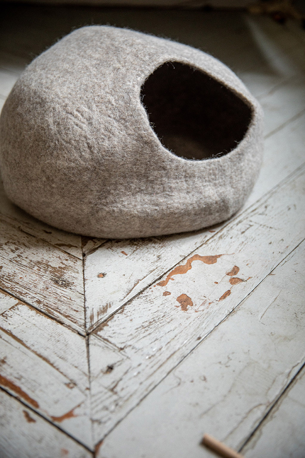 un panier en feutre gris posé sur le sol