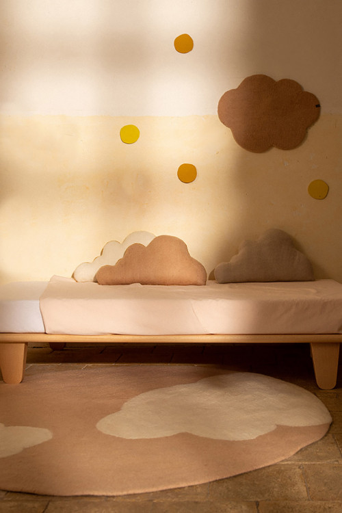 Round pink wool carpet with cloud pattern in a child's room