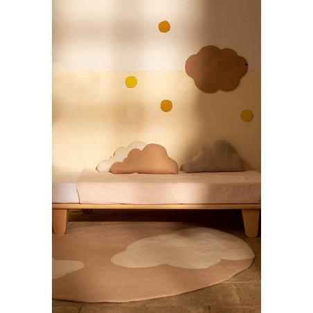 Round pink wool carpet with cloud pattern in a child's room