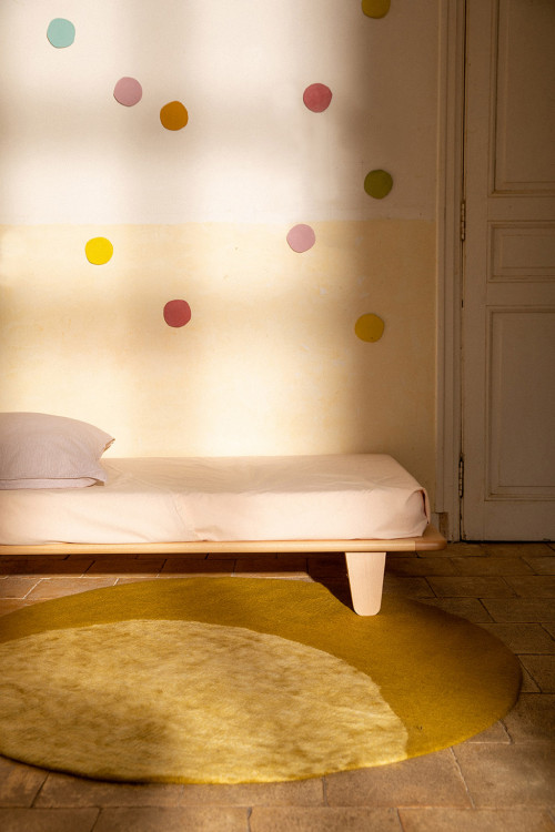 Round boiled wool carpet with moon print for the playful decoration of a child's room Round boiled wool carpet with moon print for the playful decoration of a child's room