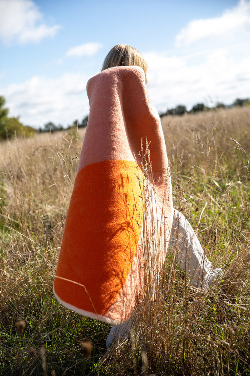 Woman carrying a round orange felted wool rug Woman carrying a round orange felted wool rug
