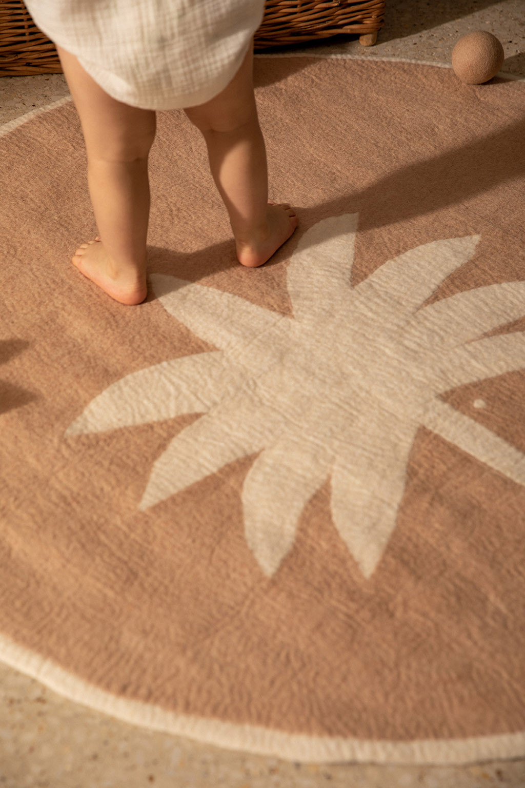 Round pink carpet for children in felted wool with palm tree print