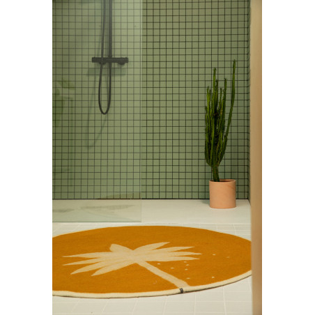 Round ochre wool felt bath mat with palm tree print