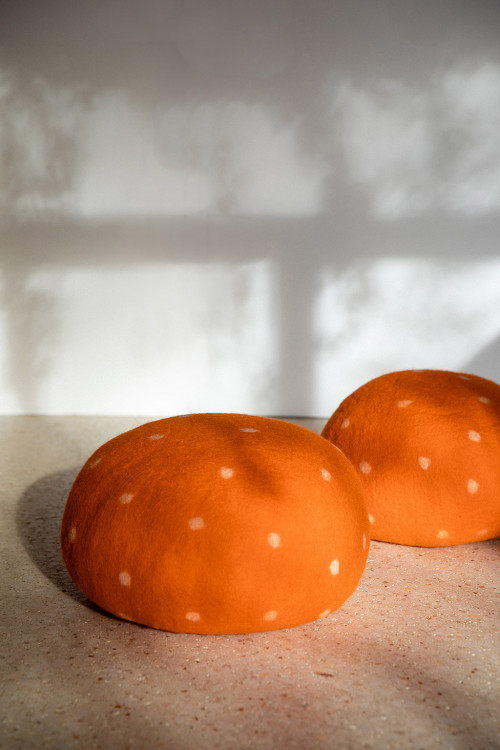 Two orange felted wool poufs reminiscent of mushrooms Two orange felted wool poufs reminiscent of mushrooms
