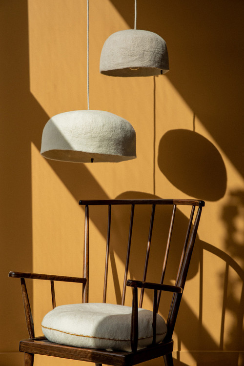 A reading corner with a pair of felted wool lights