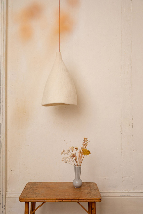 A felt lampshade hanging over a side table