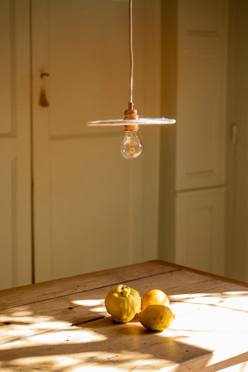 Lampe suspendue en feutre et table en bois brut pour un coin repas authentique Lampe suspendue en feutre et table en bois brut pour un coin repas authentique