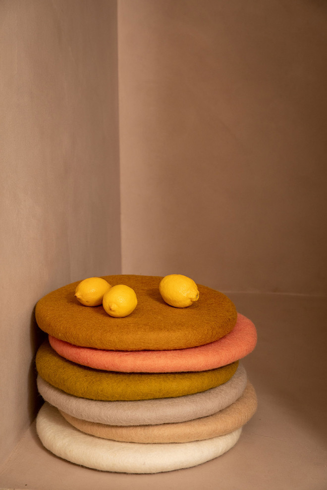 Felt ball placed on a pile of chair cushions.