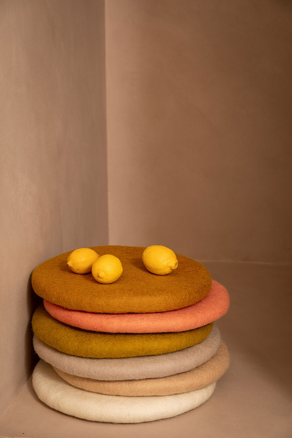 Stack of felted wool chair cushions for a colorful atmosphere