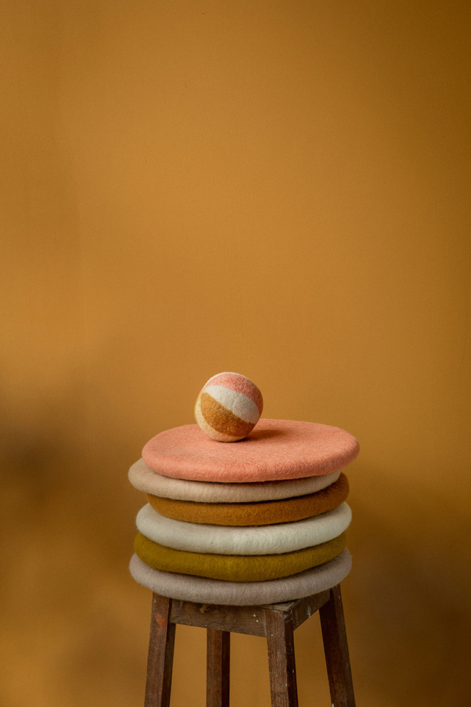 Felt ball placed on a pile of chair cushions.