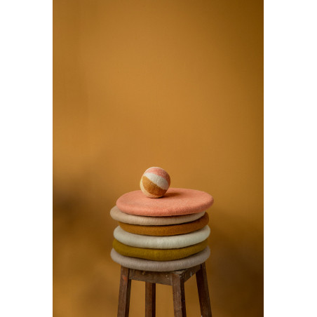 Balle en feutre posée sur une pile de galette de chaise.