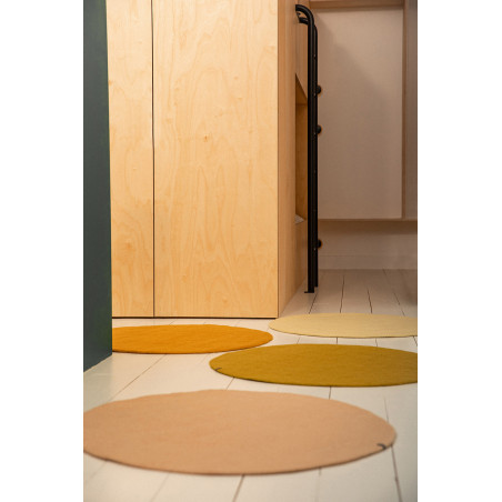 4 small round wool felt rugs in a room