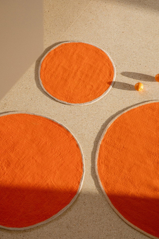 Accumulation of felt rugs with coloured borders to warm up the atmosphere