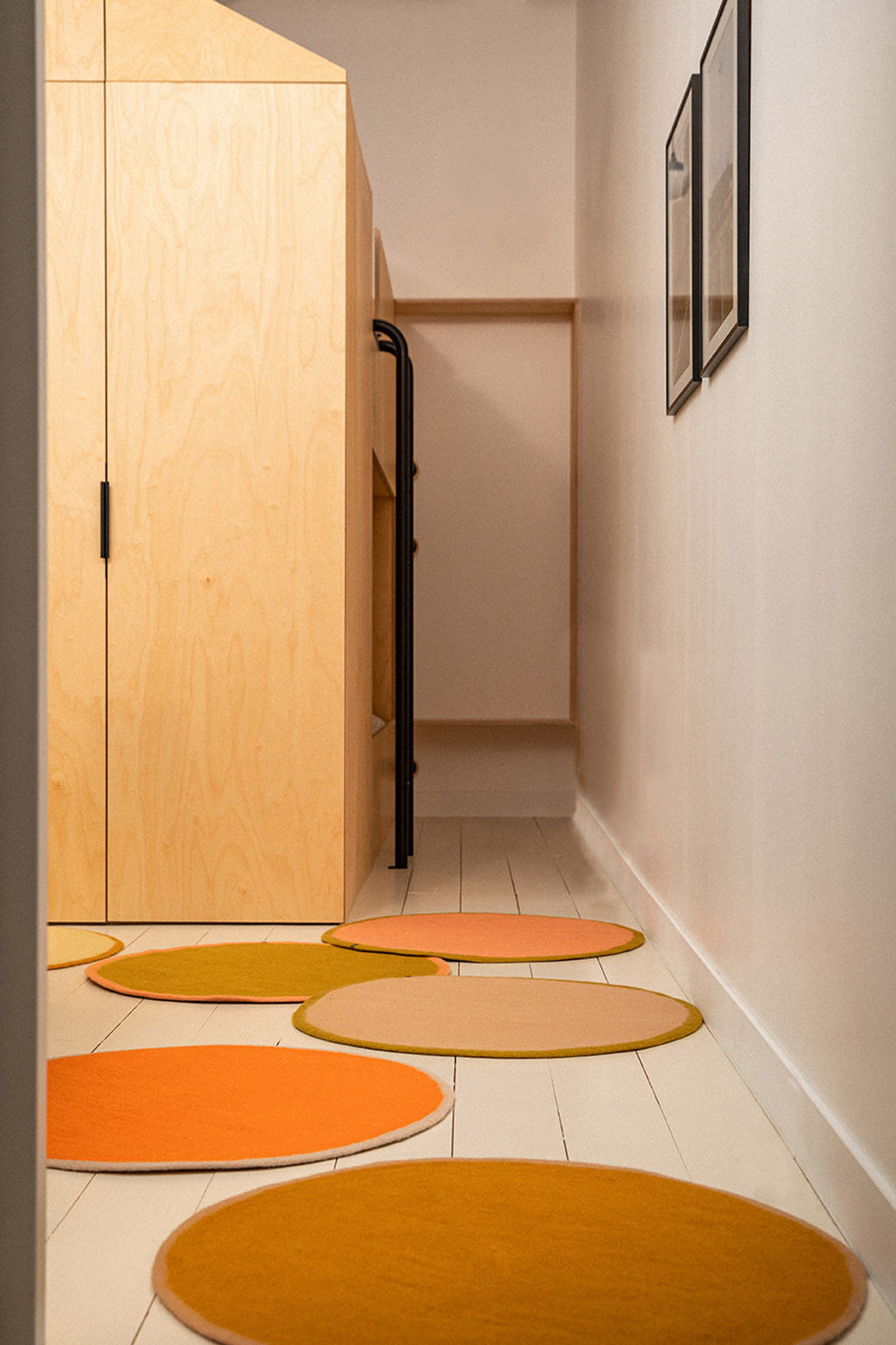 Accumulation of felt rugs with coloured borders to warm up the atmosphere