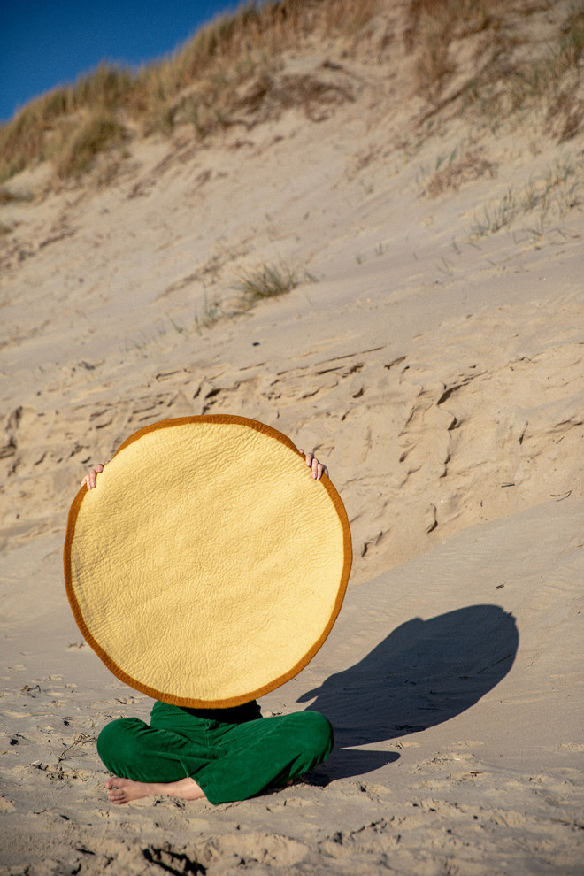 Accumulation of felt rugs with coloured borders to warm up the atmosphere