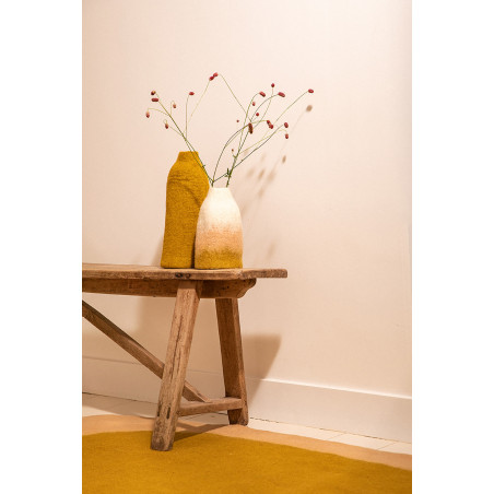 Duo de cache-vases colorés en laine bouillie posé sur un banc en bois